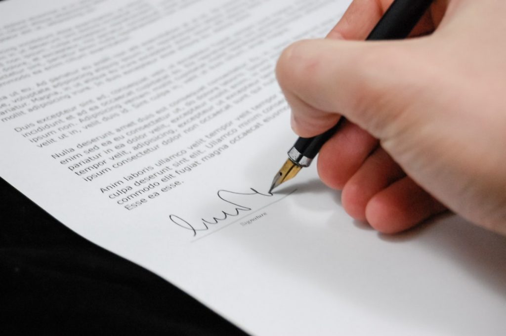 man signing a document