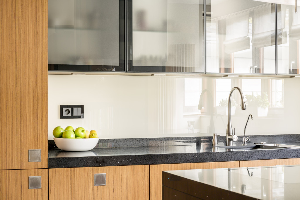 A modern kitchen with storage space and a bowl of fruits