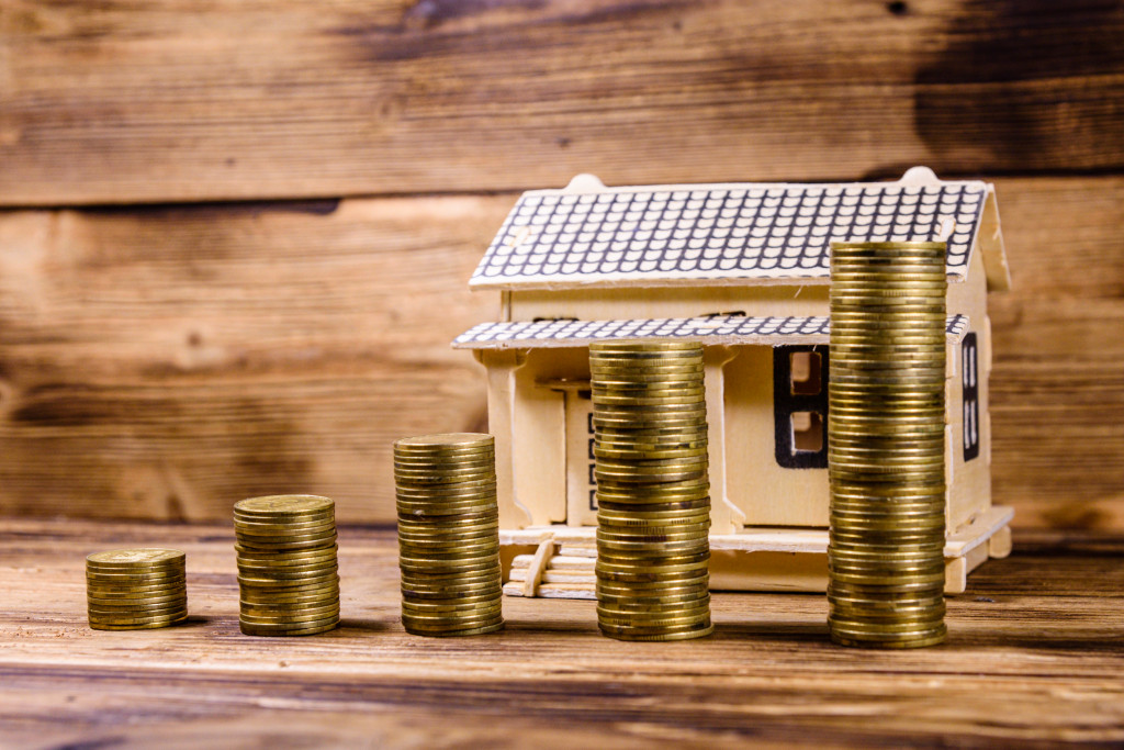 Plywood model of house and stacks of coins