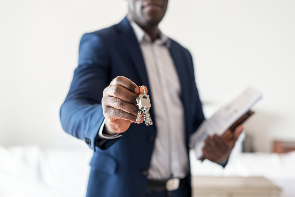 A real estate agent holding out a set of keys