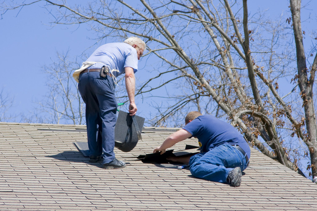 two male roofers fixing a roof