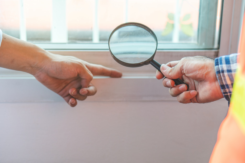 two people holding a magnifying glass over the window